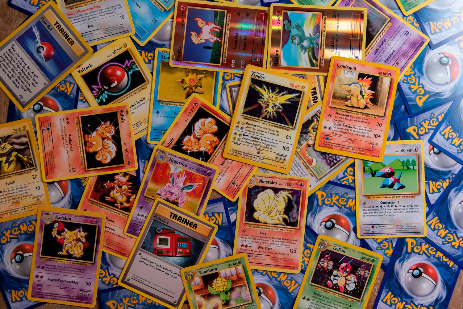 Colección de cartas de Pokémon en un fondo colorido con diversos personajes y estadísticas